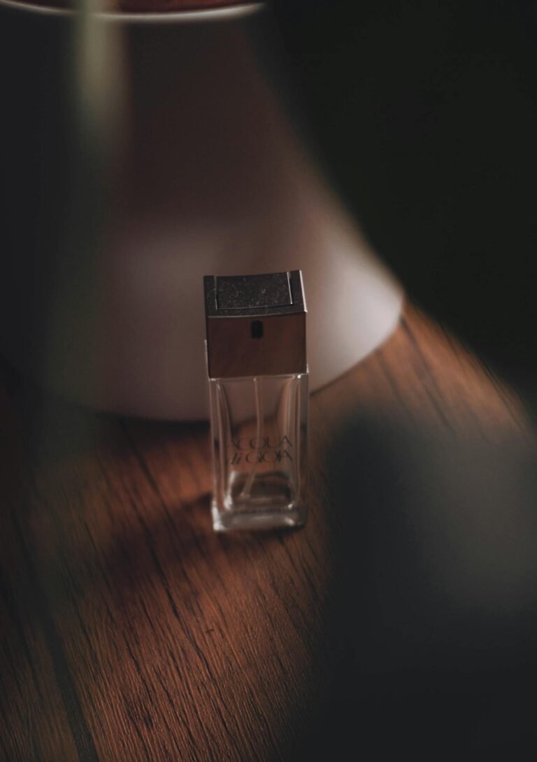 Artistic shot of a glass perfume bottle atop a textured wooden surface. Perfect for branding.